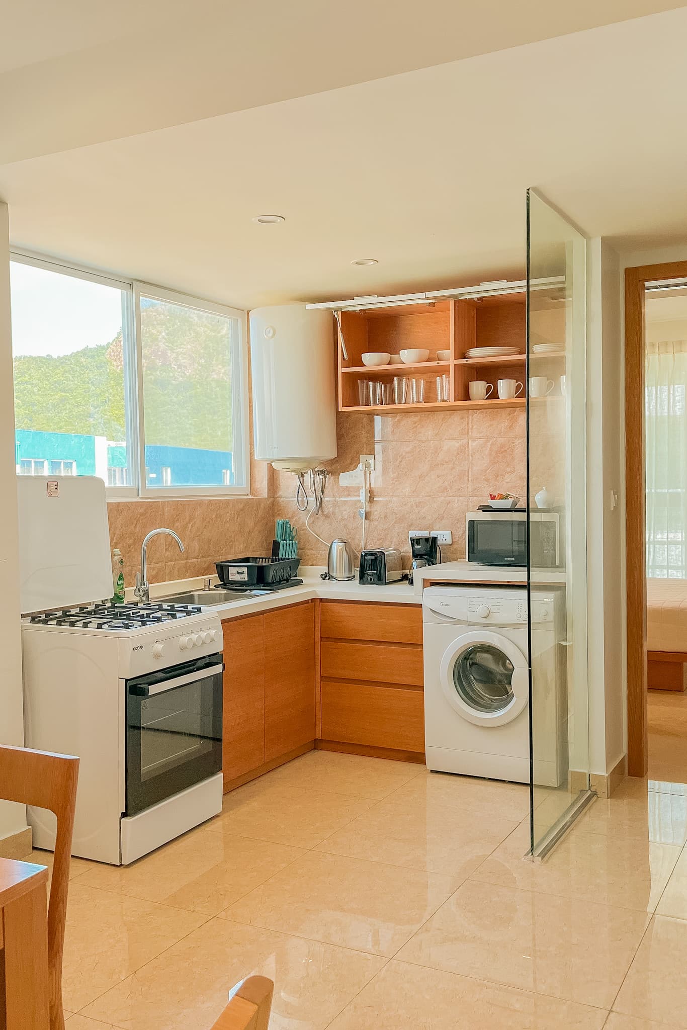 Kitchen with dining area, stove, sink, washing machine, and cabinets