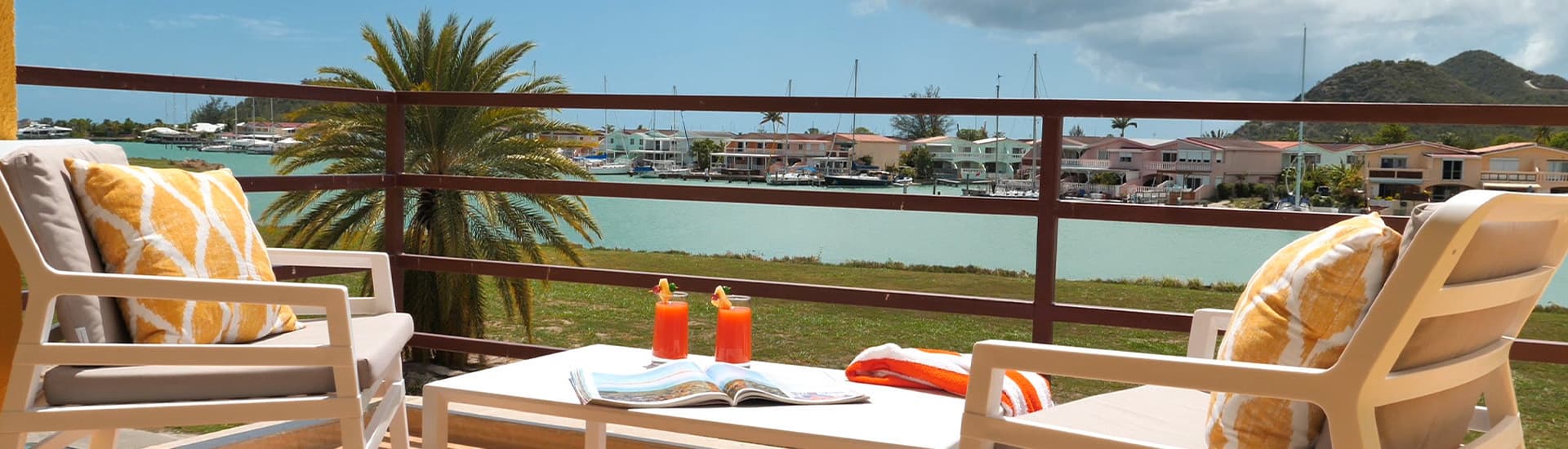 Two chairs with juice on a table and harbor view