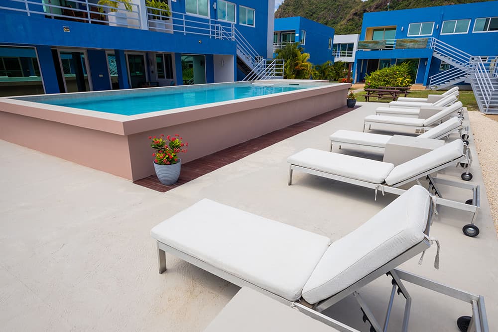 Pool at Harbour Island Residences with white lounge chairs and blue buildings in the background