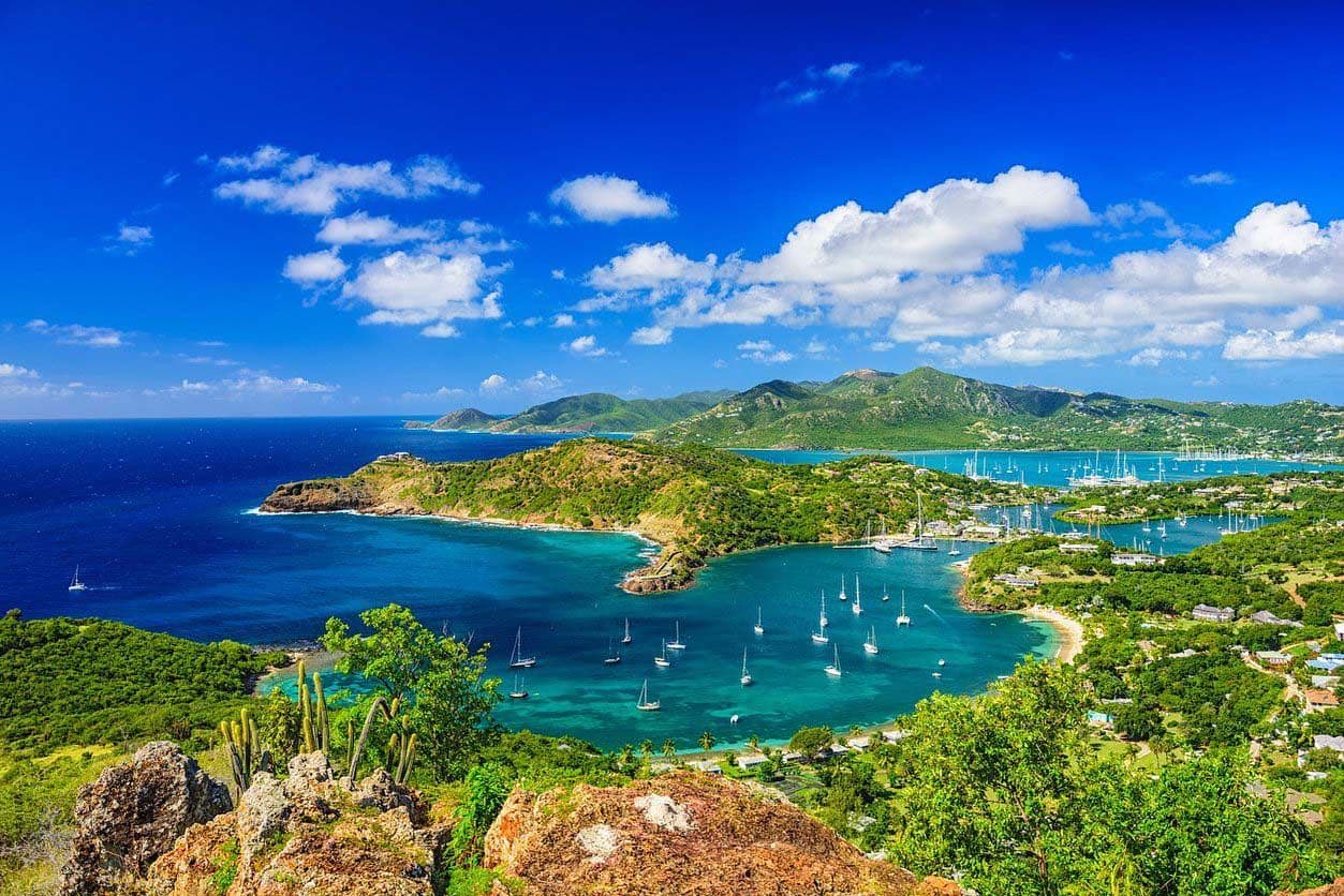 A scenic view of Antigua and Barbuda, showcasing the island's stunning coastline, turquoise waters, and vibrant marina