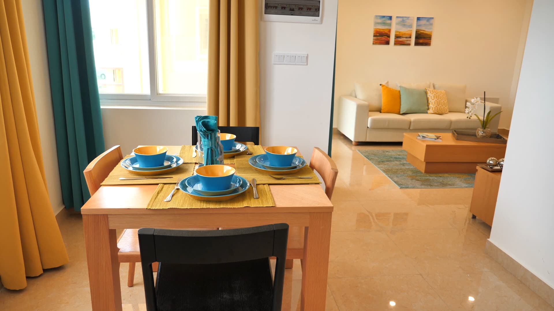 Dinning table set for four with sofa and living room in background